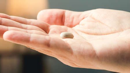 Close up of withe pills on hand