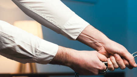 Hand of the boss in the office pulls an employee with a chain
