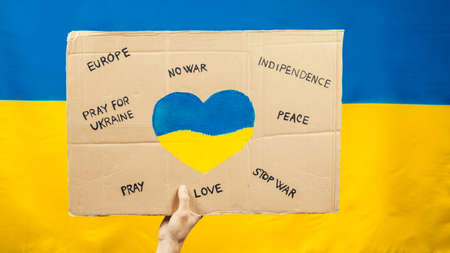Sign saying, Peace and No War in Ukraine with blue and yellow flag backgroundの写真素材