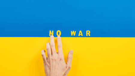 Hand writes with letters text no war on the flag of Ukraine.の写真素材