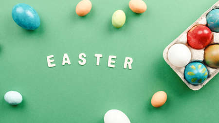 Easter text on a blue background with colored eggsの写真素材
