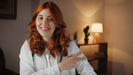Beautiful Italian woman doctor makes the symbol of the anti covid 19 vaccine.の写真素材