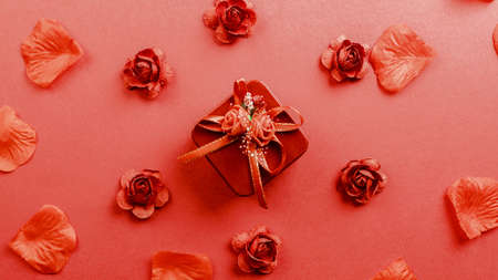 Red gift with petals falling down on the backgroundの写真素材