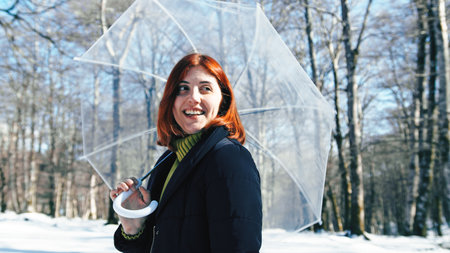 Lady with umbrella in the snowy forest