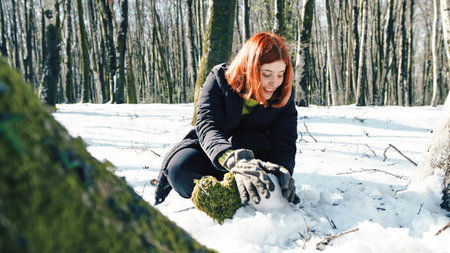 Young woman in the mountain playing with snow