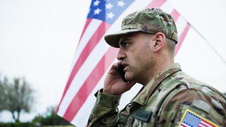 American Military Man Talks On The Phone With His Wife On The Base At War