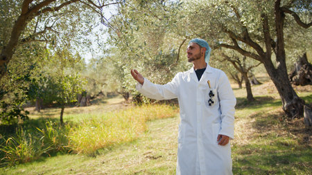 Specialist taking a quality check at a group of olive treesの写真素材
