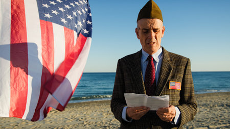 American Veteran Reads Speech On Beach In Front Of Flag Near Ocean