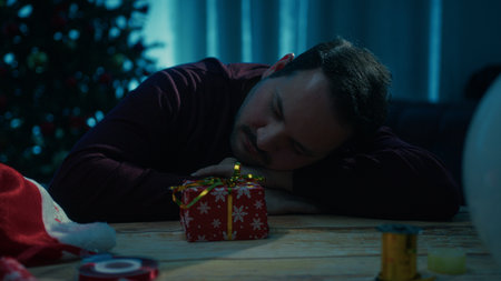 Silhouette Of Young Tired Man Sleeps On Desk At Night Christmas Eveの写真素材