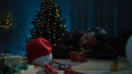Young Man Falls Asleep At Night Making Christmas Gifts On Desk