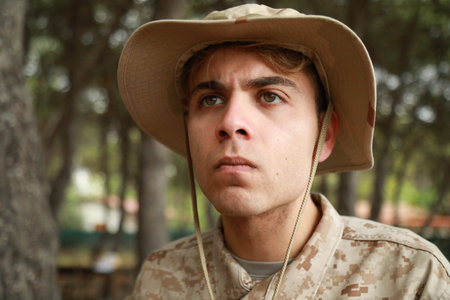 Young Man Hides From The Enemy Behind A Log In The Forest In War