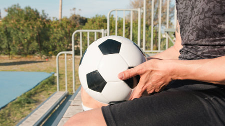 Neighborhood Boy Sitting In The Stands With The Soccer Ball In His Handの写真素材