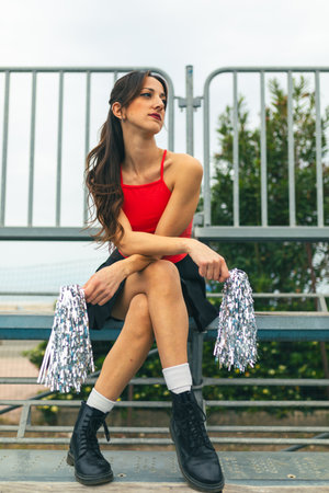 Cheerleader Girl Cheers Her Heart Basketball Team Seated On The Standの写真素材