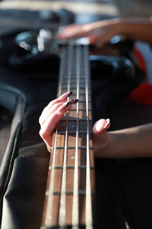 Girl Plays The Bass Sitting At The Table In A Natural Park