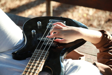 Girl Plays Bass Musical Instrument Lying On Table In Mountainsの写真素材