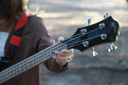 Girl Plays Bass Musical Instrument Under Trees In Mountain