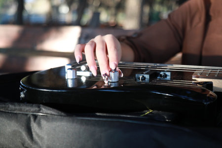 Woman Hands Turn Knobs For Tone Of Electric Bass Musical Instrumentの写真素材