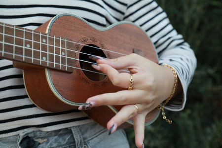 Girl Practices With Ukulele Musical Instrument In The Countryside During A Break