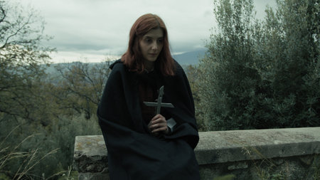 Religious Woman Prays With Crucifix In The Cemetery Among The Treesの写真素材