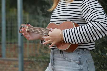 Girl Practices With Ukulele Musical Instrument During A Break