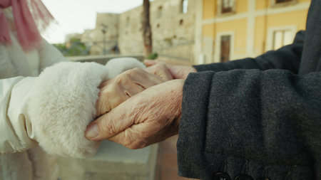 Hands Of Elderly Couple In Love Touch Each Other In The Streets Of The Cityの写真素材