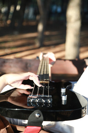 Girl Plays Bass Musical Instrument Lying On Table In Mountains
