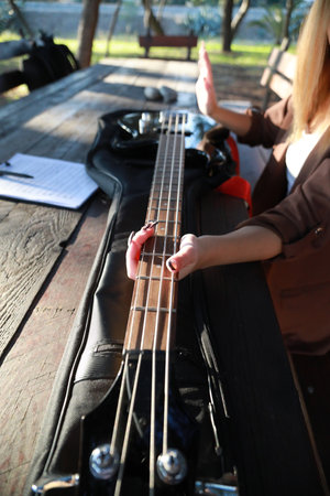 Girl Plays Bass Musical Instrument Sitting In Tableの写真素材