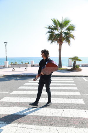 Young Man Plays Guitar On Pedestrian Crossings Of A Street In Summer