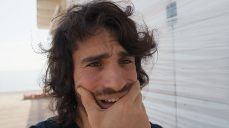 Long Hair Man Touches His Tired and Sleepy Face with Sadnessの写真素材