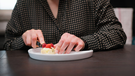 Woman Shares Fruit Pastry Food Sitting At Table In The Morningの写真素材
