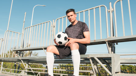 Neighborhood Boy Sitting In The Stands With The Soccer Ball In His Hand