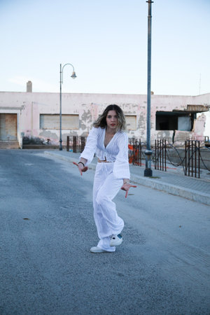 Girl Dances In White Clothes Outside On The Streetの写真素材