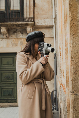 Woman Filming The Old Town Buildings With A Vintage Camera