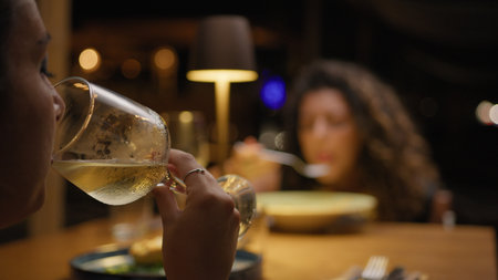 Woman Drinking Wine For The Glass During A Dinner With A Friend At The Resort