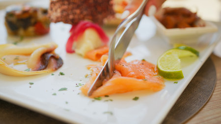 Fork And Knife Cutting A Slice Of Fresh Salmonの写真素材