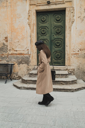 Woman In Vintage Clothing Sitting On The Bench Of The Old Townの写真素材