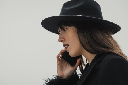 Elegant Woman In Total Black Walking With The Phone In The Townの写真素材