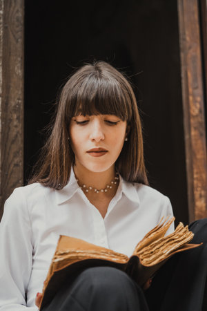 young Woman Studying Old Literature And Reading An Old Bookの写真素材