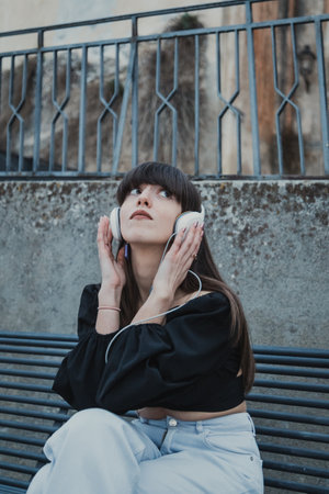 Woman Sit In The City Bench Outdoor And Relaxing With Music
