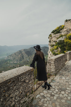 Elegant Women Posing On The Railing With A Mountain Landscape Backgroundの写真素材