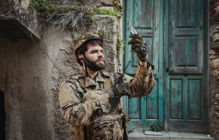 Soldier Sitting Near A Destroyed House Checks His Compass