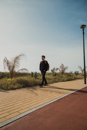 Man With Backpack Taking A Walk In The Nature Near The Grass