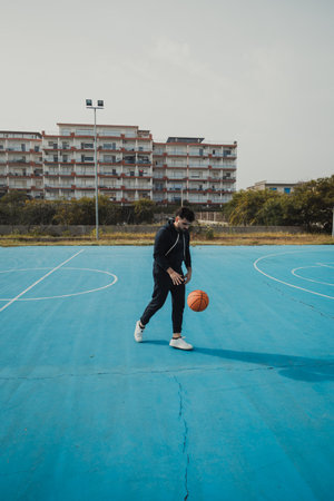 Man Dribbles a Basketball in the Park