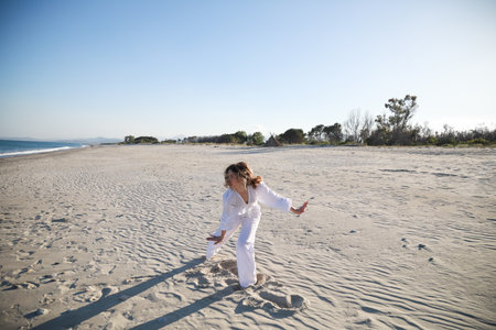 Young Italian Woman Dances On The Beach In Summer Near The Oceanの写真素材