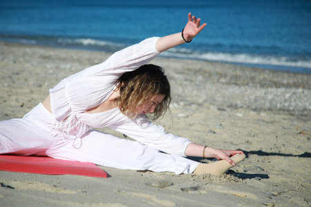 Beach Stretch Routine by Blonde Woman in the Sunの写真素材