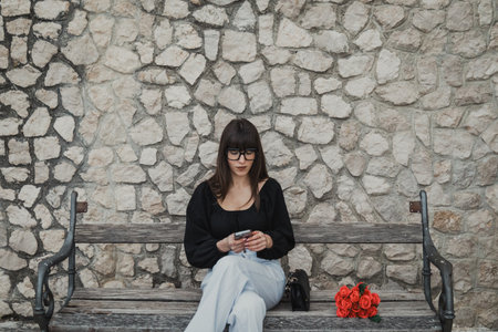 Young girl writes a text on smartphone to her boyfriendの写真素材