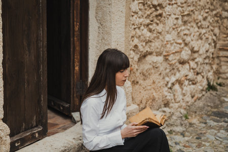 Religious Woman Reading The Bible Book At The Entrance Of The Churchの写真素材