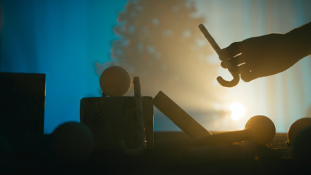 Silhouette of a man's hands arranging presents at nightの写真素材