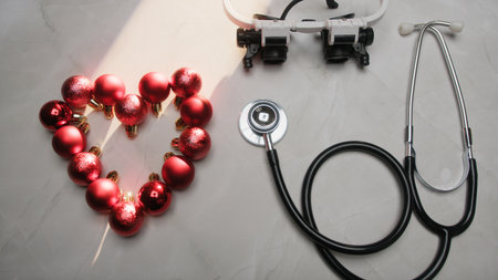 Cardiologist Doctor With Stethoscope And A Christmas Balls Heart On Backgroundの写真素材