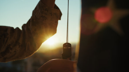 Silhouette Of A United States Soldier Holding A Dog Tag To Remember The Fallenの写真素材